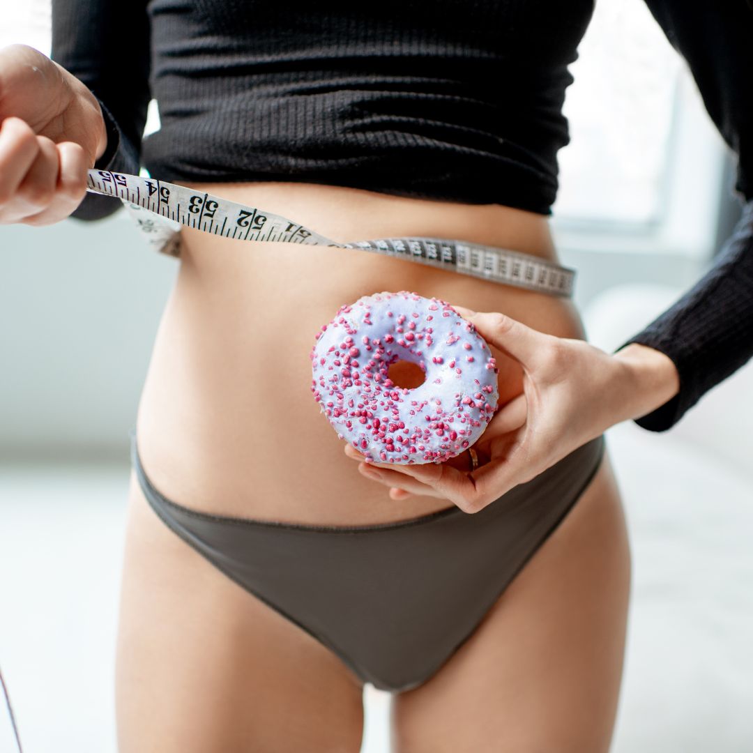 femme avec donuts dans les mains et un mètre sur la taille